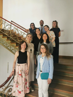 Mitglieder des Community Consulting Teams und Mitarbeiterinnen von Minor stehen zusammen auf einer Treppe im BMAS