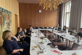 Mitglieder des Community Consulting Teams diskutieren mit einer Vertreterin und einem Vertreter des BMAS